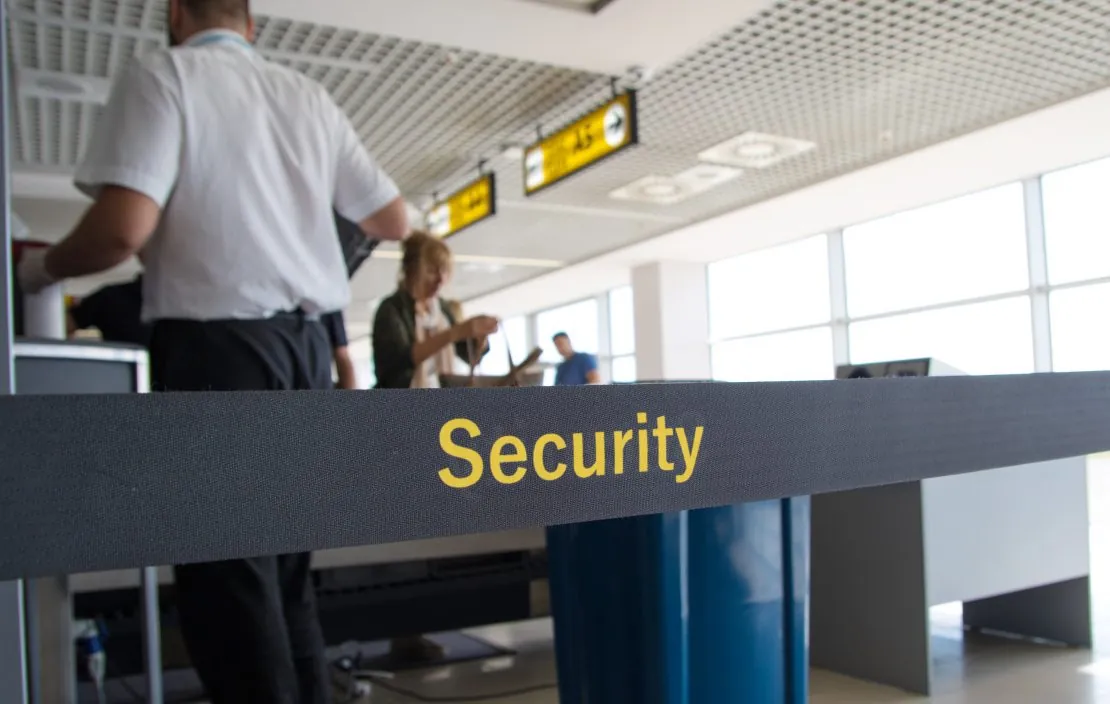 Man scanning luggage at airport security checkpoint