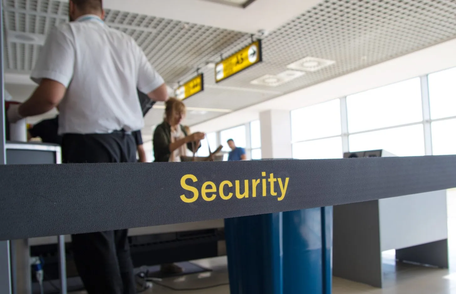 Man scanning luggage at airport security checkpoint